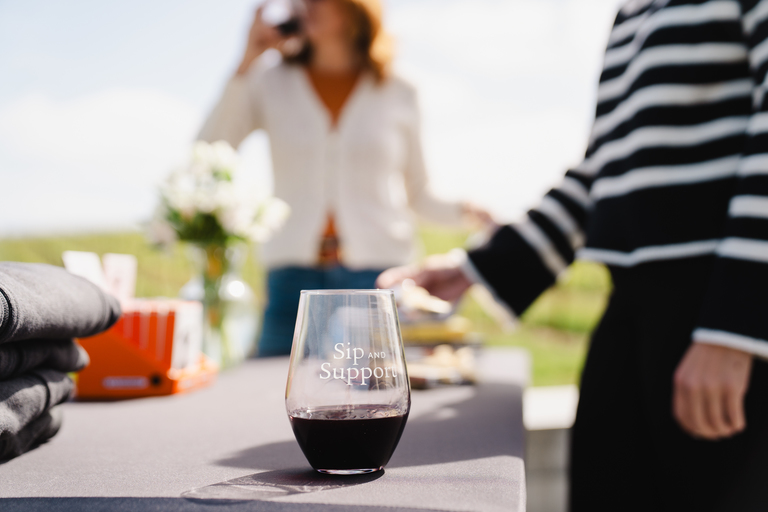 Women with wine glasses at a market table